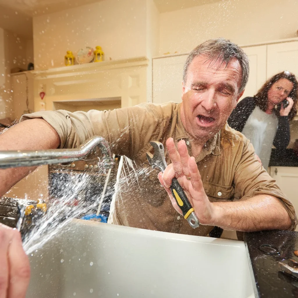 A broken faucet spraying at man and woman